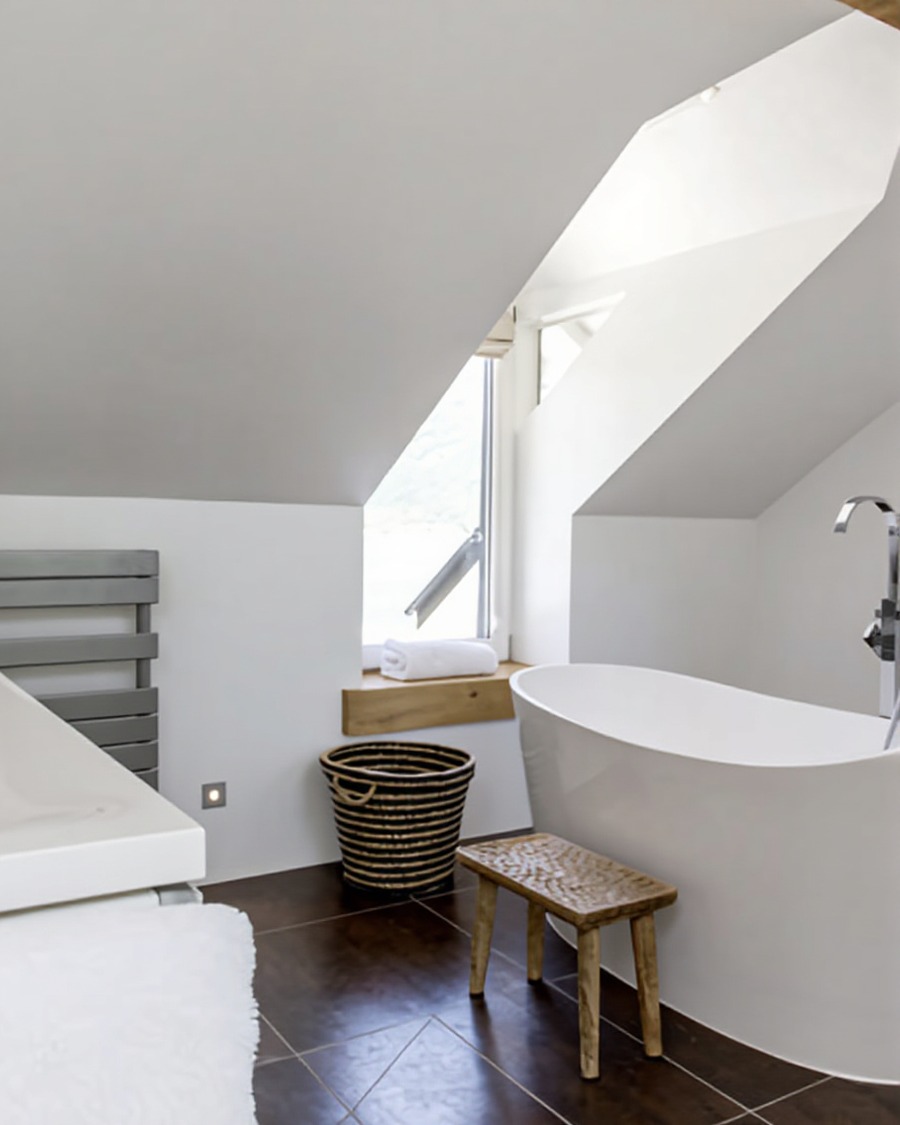 Attic bathroom with angular dormer, freestanding bath, woven basket and timber stool