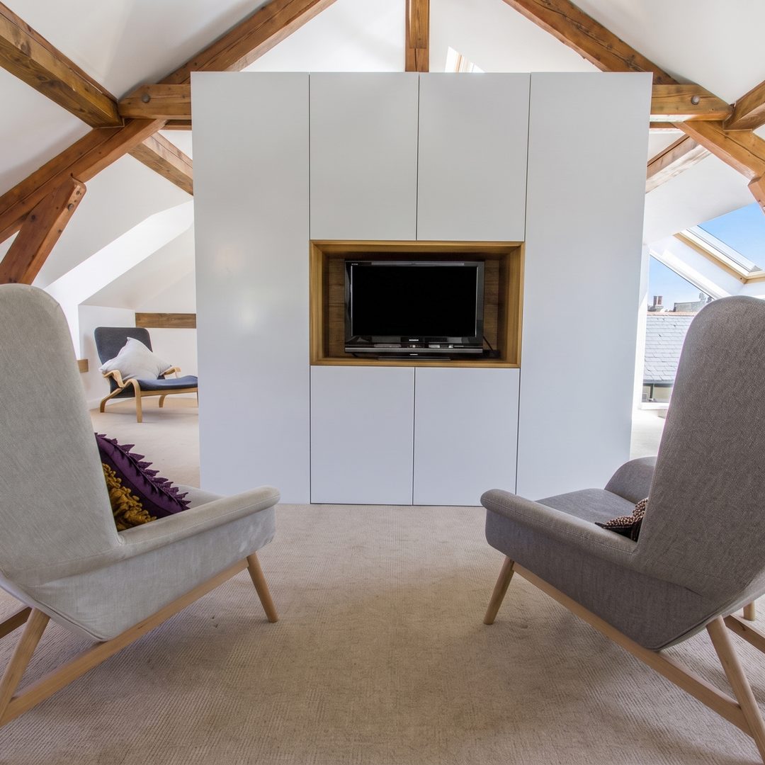Attic conversion living room with a raked ceiling and exposed timber trusses